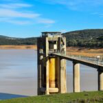 Beni M'Tir Dam with scenic reservoir and rolling hills under a clear blue sky, Tunisia.