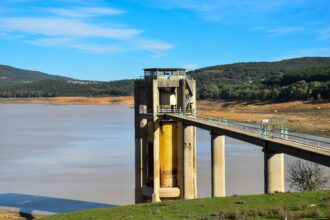 Beni M'Tir Dam with scenic reservoir and rolling hills under a clear blue sky, Tunisia.