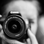 person taking photo using Canon camera in shallow focus lens