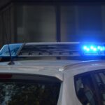 Close-up of a police car's flashing blue lights in an urban environment.