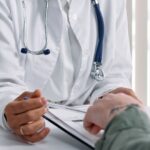 hands of doctor and patient on table